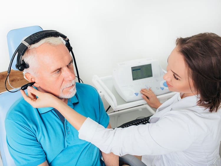 doctor administering hearing test on older man