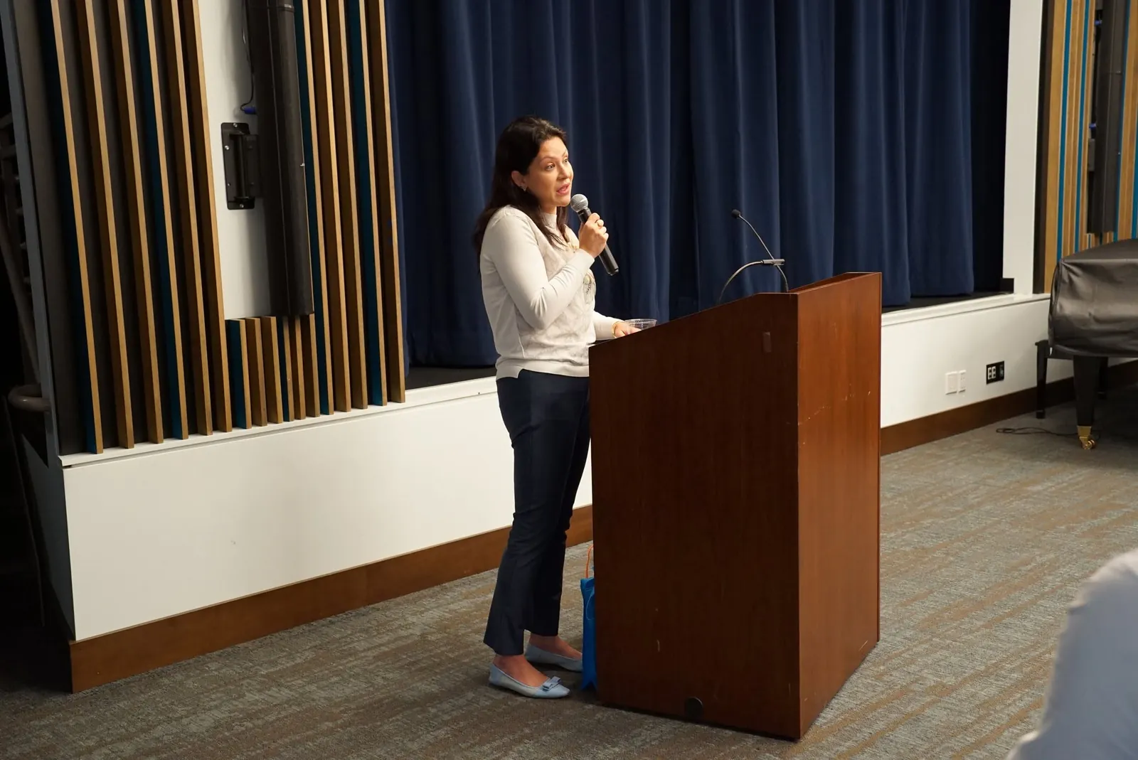 Dr. Kira Savin, a doctor of audiology and partner at Audiology Associates of Westchester, speaking at the podium during a hearing care talk in San Francisco