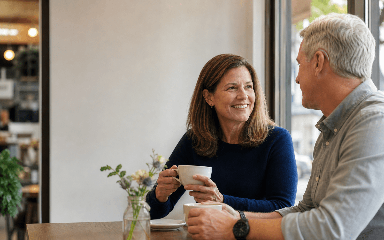 Two adults having an easy conversation at a cafe