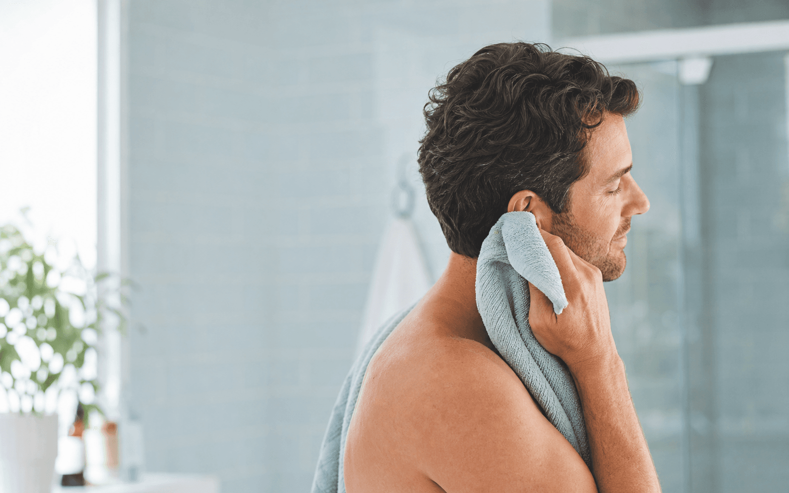 Adult gently drying the outside of an ear with a towel